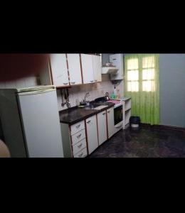 a kitchen with white cabinets and a sink and a refrigerator at Amanecer in Uspallata