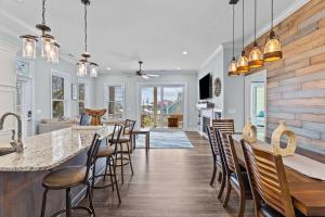 a kitchen and living room with a table and chairs at Maison by The Sea at Kure Beach in Kure Beach