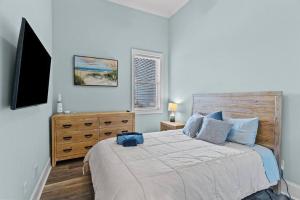 a bedroom with a large bed and a television at Maison by The Sea at Kure Beach in Kure Beach