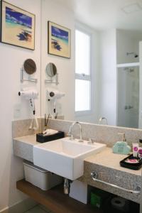 W łazience znajduje się umywalka i lustro. w obiekcie Apart-hotel TrueAmérica w mieście Campos dos Goytacazes