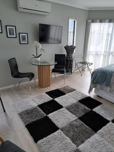 1 dormitorio con alfombra blanca y negra a cuadros en Sunbrae Beach Sanctuary free high Fibre wifi, en Mount Maunganui