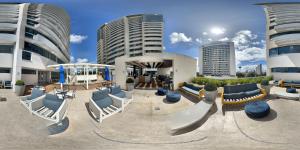 ein Gebäude mit Stühlen und Tischen und Gebäuden in der Unterkunft Apart-hotel TrueAmérica in Campos dos Goytacazes