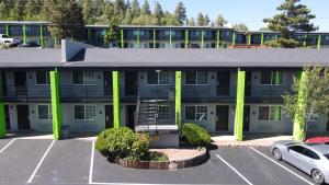 un bâtiment avec des colonnes vertes et un parking dans l'établissement Hotel Aspen Flagstaff/ Grand Canyon InnSuites, à Flagstaff