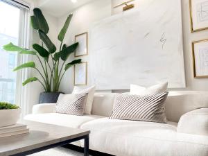 a living room with a white couch and a plant at Modern and Bright Luxury Home Centrally Located in Toronto’s GTA in Toronto