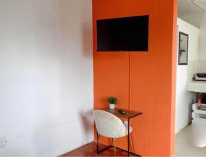 Habitación con mesa con silla y TV en la pared. en Urban Hotel, en Guatemala