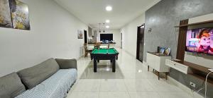 Casa do Sonho, Piscina, Sinuca, Churrasqueira في مارينجا: غرفة معيشة مع أريكة وطاولة بلياردو