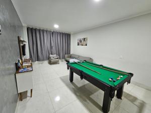 uma sala de estar com uma mesa de bilhar em Casa do Sonho, Piscina, Sinuca, Churrasqueira em Maringá