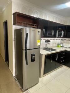 eine Küche mit einem Kühlschrank und Schränken aus Edelstahl in der Unterkunft Apartamento 2 habitaciones in Barranquilla