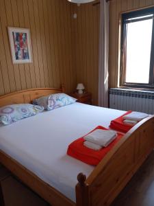 1 cama grande de madera en un dormitorio con ventana en Apartments with parking space Pag - 18325, en Pag