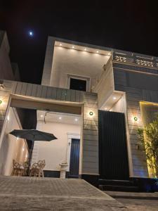 a house with an umbrella in front of it at night at بيت النرجس الخاص in Riyadh