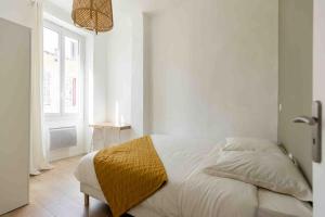 ein weißes Schlafzimmer mit einem Bett und einem Fenster in der Unterkunft Appart cosy à 1’ du Cours Julien (Climatisé) in Marseille