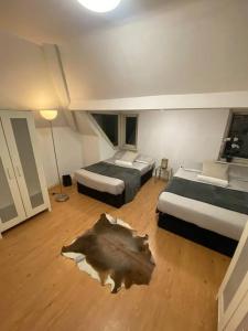 a bedroom with two beds and a wooden floor at Penthouse studio with 2 double beds & smart TV. Great London Location in London