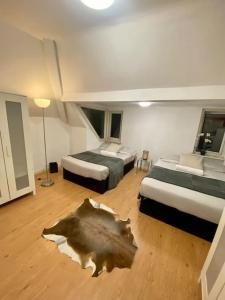 a bedroom with two beds and a wooden floor at Penthouse studio with 2 double beds & smart TV. Great London Location in London