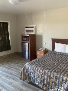 um quarto de hotel com uma cama e um micro-ondas em Ranger Motel em El Reno