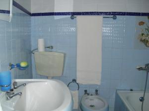 a blue tiled bathroom with a toilet and a sink at Casa Marina Olhao in Olhão