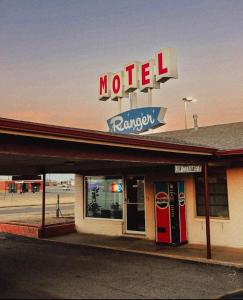 um motel com uma placa e duas máquinas de refrigerante em Ranger Motel em El Reno