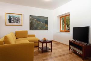 uma sala de estar com um sofá e uma televisão de ecrã plano em Family friendly house with a swimming pool Pucisca, Brac - 21243 em Pučišća