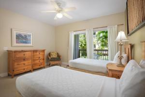 a bedroom with two beds and a window at Aston At Poipu Kai in Koloa