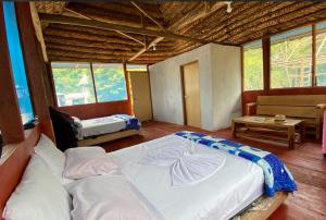 a bedroom with a large bed in a room with windows at Ceiba Amazon Lodge in Iquitos