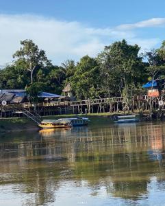 two boats are docked on a river with a bridge at Ceiba Amazon Lodge in Iquitos