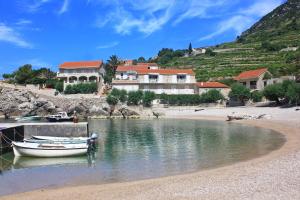 a boat is docked on the shore of a beach at Apartments with parking space Borje, Peljesac - 21496 in Orebić