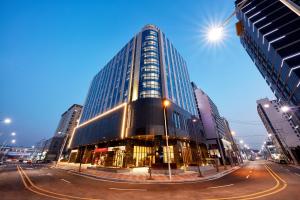 een hoog gebouw in een stadsstraat 's nachts bij Pyeongtaek K-tree Hotel in Pyeongtaek