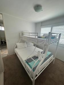 a bedroom with two bunk beds in a room at 2 Bedroom Top Floor Unit - Ocean Views and Pool in Alexandra Headland