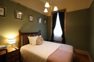 um quarto com uma cama e uma janela em The Exchange Hotel - Offering Heritage Style Accommodation em Beaconsfield