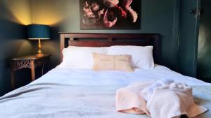 Una cama con sábanas blancas y toallas. en Allawa- Central & Cosy Ballarat Art Deco en Ballarat