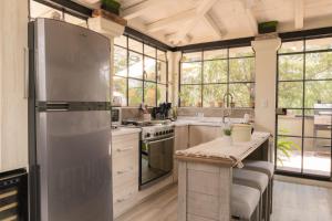 a kitchen with a stainless steel refrigerator and windows at Hotel Casa Guadiana in San Miguel de Allende