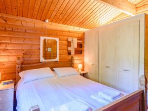 a bedroom with a bed in a wooden cabin at Scandinavian Lodge - Uk37188 in Legbourne