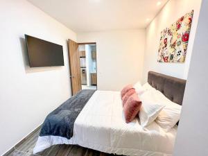 a bedroom with a bed with pillows and a flat screen tv at 401S Refugio para ti en Ibague in Ibagué
