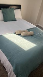 a bed with two towels on top of it at Seven Sister's rooms in London