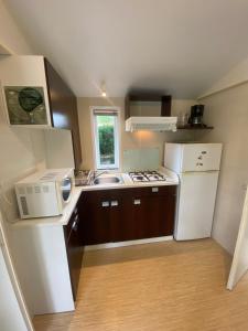 a small kitchen with a sink and a microwave at Séjour inoubliable en Provence, camping 3 étoiles in La Roque-dʼAnthéron