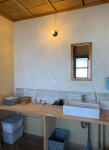 a bathroom counter with a sink and a mirror at 跳びしまBASE in Mitarai