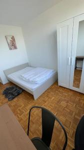 ein kleines Zimmer mit einem Bett und einem Stuhl in der Unterkunft 30 min de Paris Grand appartement neuf et lumineux in Cergy