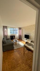 ein Wohnzimmer mit einem Sofa und einem Tisch in der Unterkunft 30 min de Paris Grand appartement neuf et lumineux in Cergy