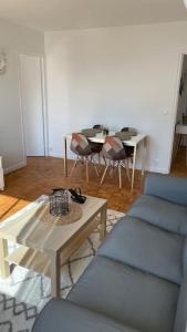 ein Wohnzimmer mit einem Sofa und einem Tisch in der Unterkunft 30 min de Paris Grand appartement neuf et lumineux in Cergy