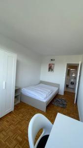 Kleines Zimmer mit einem Bett und einem Tisch in der Unterkunft 30 min de Paris Grand appartement neuf et lumineux in Cergy