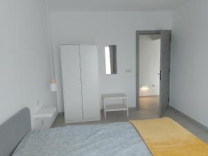 ein weißes Zimmer mit einem Bett und einer Tür in der Unterkunft Casa Bidarta in Faja Grande