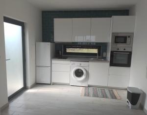uma cozinha branca com uma máquina de lavar roupa em Casa Bidarta em Faja Grande