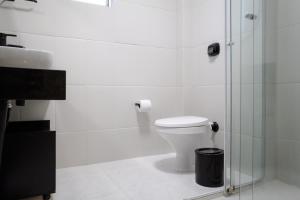 a bathroom with a toilet and a glass shower at Cidade das Bicicletas in Joinville