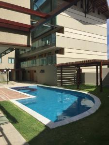 a swimming pool in front of a building at Manawa Beach Flat A24 - Centro Porto de Galinhas in Porto De Galinhas