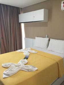 a hotel room with two white towels on a bed at Manawa Beach Flat A24 - Centro Porto de Galinhas in Porto De Galinhas