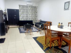 關丹的住宿－Homestay Izzauni，客厅配有桌子和沙发