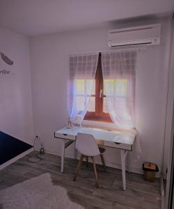 biurko z krzesłem w pokoju z oknem w obiekcie Villa TYNO w mieście Le Moule
