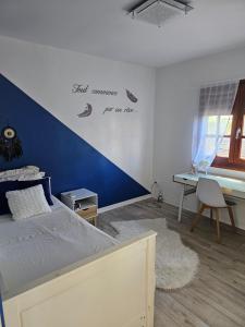 una camera da letto con un letto con una parete con accento blu di Villa TYNO a Le Moule