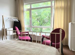 sypialnia z 2 krzesłami, łóżkiem i oknem w obiekcie Turquoise by Mercan Homes - Cozy House w/2 BR,Close to City Center, Metro, Malls w Stambule