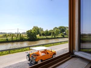 pomarańczowy samochód zaparkowany na poboczu drogi w obiekcie Beautiful Holiday Home with Terrace Garden w mieście Diksmuide