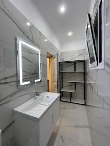 La salle de bains blanche est pourvue d'un lavabo et d'un miroir. dans l'établissement Guesthouse BellaVista, à Berat